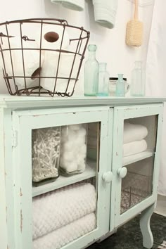 a bathroom cabinet with towels and other items in it