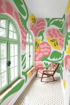 the room is decorated in bright colors and has an open window with green shutters