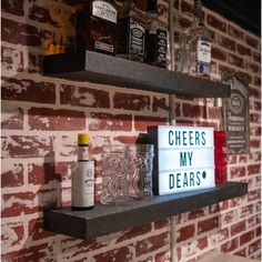 a shelf with liquor bottles on it and a sign that says cheers my dears