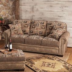 a living room with a couch, chair and ottoman next to a stone fireplace mantel