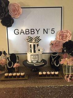 a table topped with cakes and cupcakes next to a sign that says gabby n 5