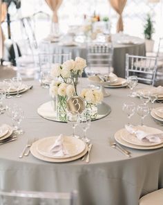 the table is set with white flowers and silverware for an elegant wedding reception or special event