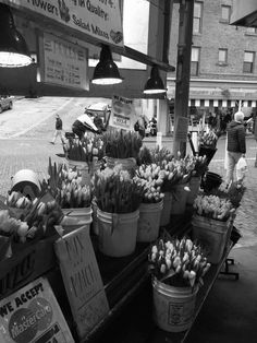 black and white photograph of flowers for sale at an outdoor market