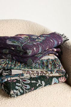 three blankets stacked on top of each other next to a pile of carpeted material