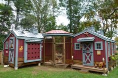 a small red and blue shed with two doors on the side, surrounded by trees