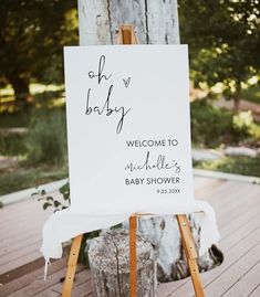 a welcome sign for a baby to be placed on a wooden easel in front of a tree