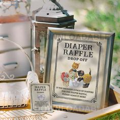 an old fashioned diaper raffle drop - off sign and other items on a table