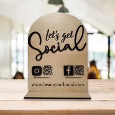 a wooden sign with the words let's get social on it sitting on top of a table