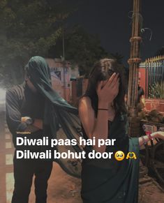 a woman covering her face while standing next to a man in front of a street light