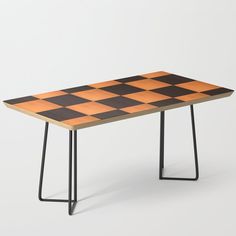 an orange and black checkerboard table with metal legs, on a white background