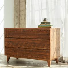 a wooden dresser sitting in front of a window