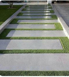 a walkway made out of concrete and artificial grass