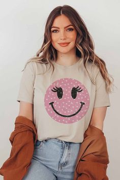 Wink Smiley Face Graphic T-Shirt. Designed for comfort and style. 100% Premium Cotton Unisex Sizing Classic Fit Funny Print Short Sleeve T-shirt For Loungewear, Trendy Smiley Face Loungewear Tops, Trendy Smiley Face Tops For Loungewear, Fun Crew Neck T-shirt For Loungewear, Pink T-shirt With Funny Print For Everyday Wear, Fun White Everyday T-shirt, Trendy White Shirt For Loungewear, Pink Graphic Tee With Smiley Face, White Graphic Tee With Smiley Face