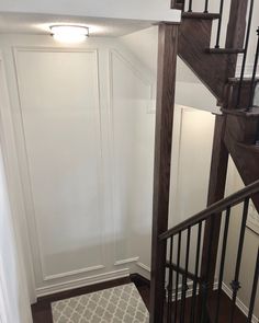 an empty room with a stair case in the corner and a rug on the floor