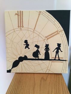 the silhouettes of people are on top of a wooden table with a clock in the background