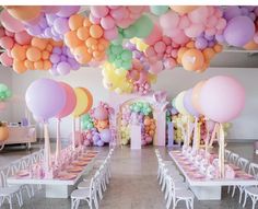 a room filled with lots of balloons and tables