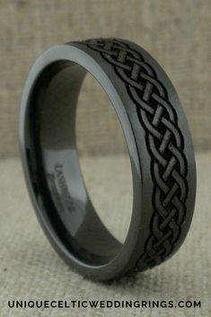 a wedding ring with an intricate design on the inside is shown in black and silver