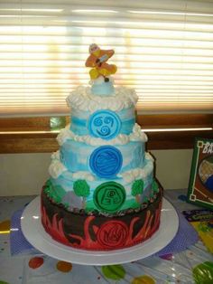 a multi layer cake on a table in front of a window with the top tier covered in icing