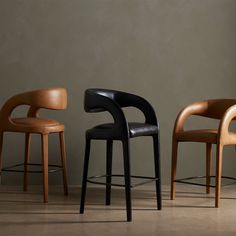 three modern chairs in different colors and sizes, one with a black seat on the other