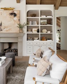 a living room filled with furniture and a fire place under a painting on the wall