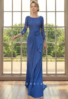 a woman standing in front of a window wearing a blue dress