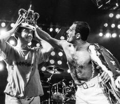 two men standing next to each other on stage with lights in the background and one holding up a trophy