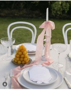 a table set with plates, silverware and napkins for an outdoor wedding reception