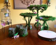 a wooden table topped with lots of fake trees