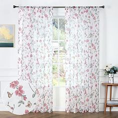 the curtains in this room are decorated with flowers and butterflies, while the window curtain is closed