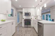 a kitchen with white cabinets and stainless steel appliances