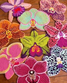 several different colored flowers on a wooden floor