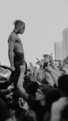 a man with dreadlocks standing on top of a stage in front of a crowd