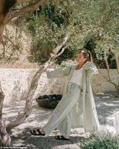 a woman standing in front of a tree