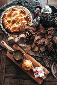 a table topped with a pie next to a cup of coffee and other food items