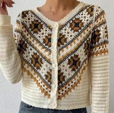 a woman wearing a white and brown cardigan sweater with crocheted details on the sleeves