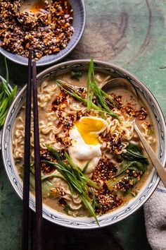 two bowls filled with noodles and topped with an egg