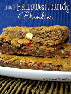 two pieces of halloween candy blondies stacked on top of each other in front of a blue background