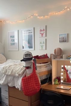 a bedroom with a bed, desk and pictures hanging on the wall above it's headboard