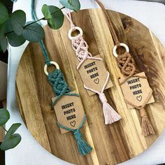 three keychains with different types of rope on top of a wooden board next to a potted plant