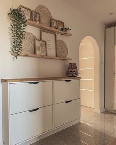 a kitchen with white cabinets and wooden shelves