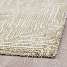 a close up view of a rug on the floor with white and light brown colors