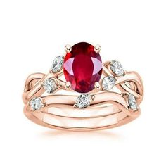 a ring set with an oval red stone and two white diamonds on the band, in rose gold