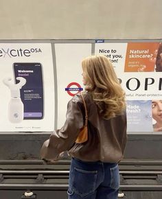 a woman standing in front of an advertisement for cell phones