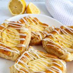 lemon meringue rolls on a plate with drizzled icing