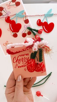 someone holding up a card with cherries on it