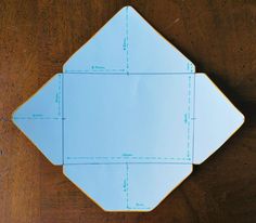 an origami piece on a wooden table with blue paper cut out to look like hexagonal shapes