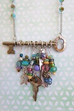 a key is attached to a necklace with charms