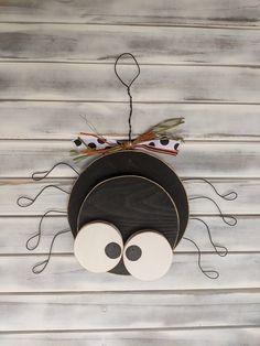 a black and white hat with eyes hanging from the side of a wooden plank wall