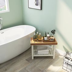 a white bath tub sitting next to a wooden table with bottles on top of it