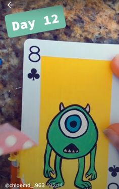 a hand holding up a card with an image of a monster on it and the words day 12